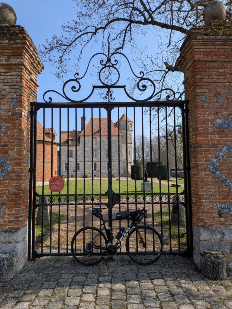 Un vélo posé devant les grilles d'un château