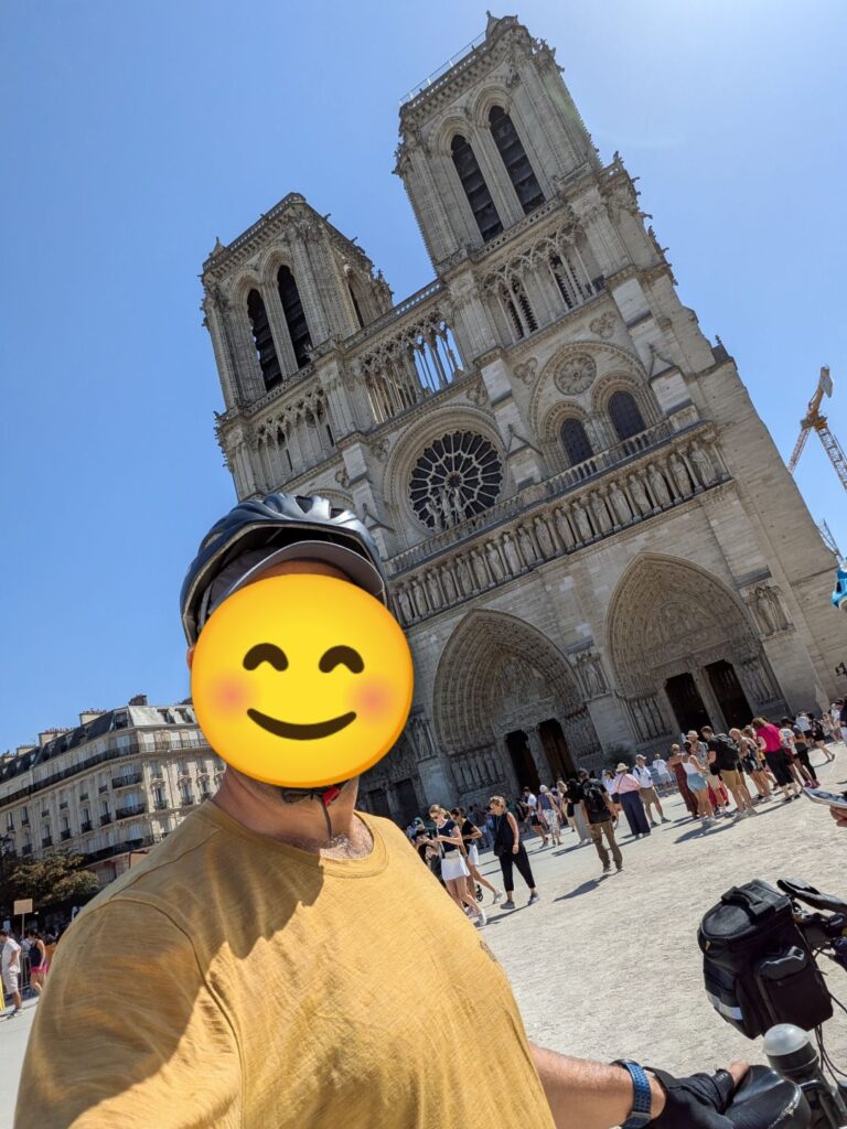 Autoportrait d'une personne dont le visage est masqué par un smiley, derrière Notre-Dame de Paris