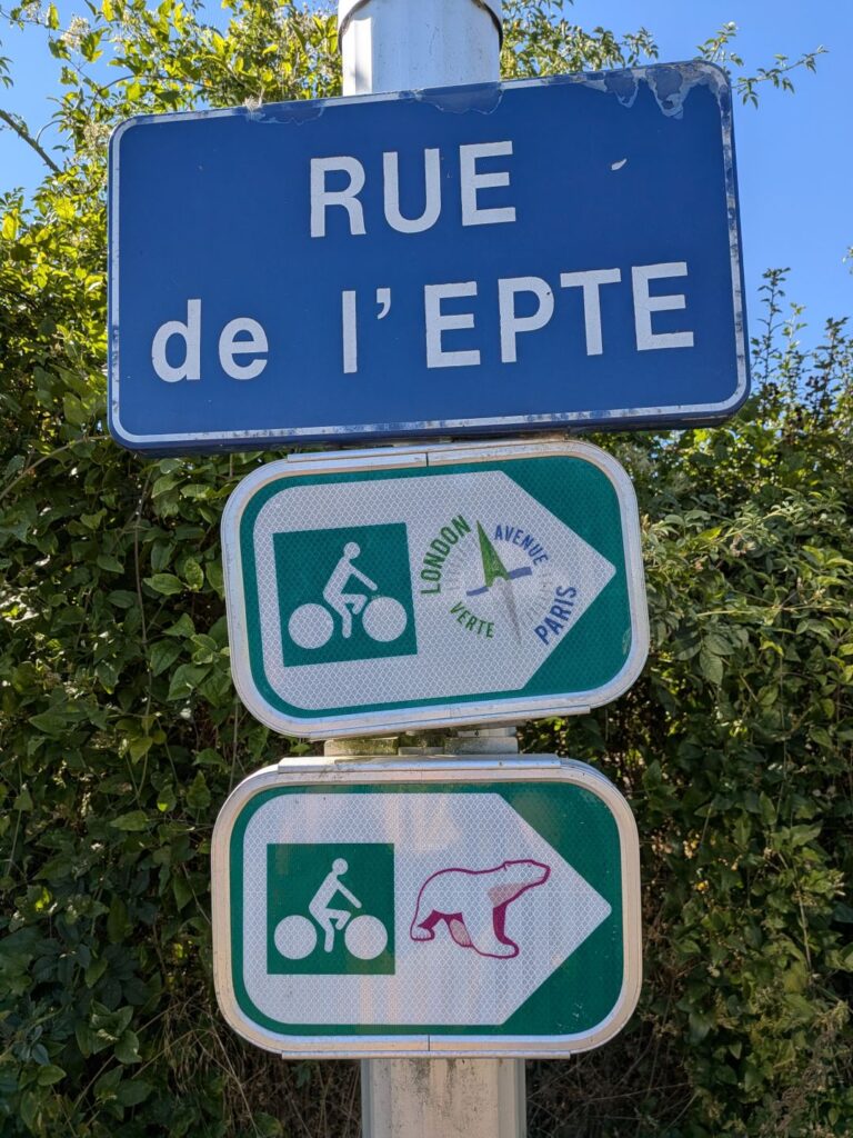 Panneaux de signalisation de voies vertes, l'une l'avenue verte, l'autre présentant une vue stylisée de l'ours de l'artiste Ponpon