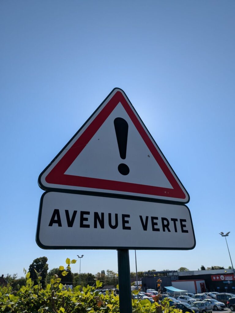 Panneau de circulation triangulaire avec un point d'exclamation et texte "Avenue verte"