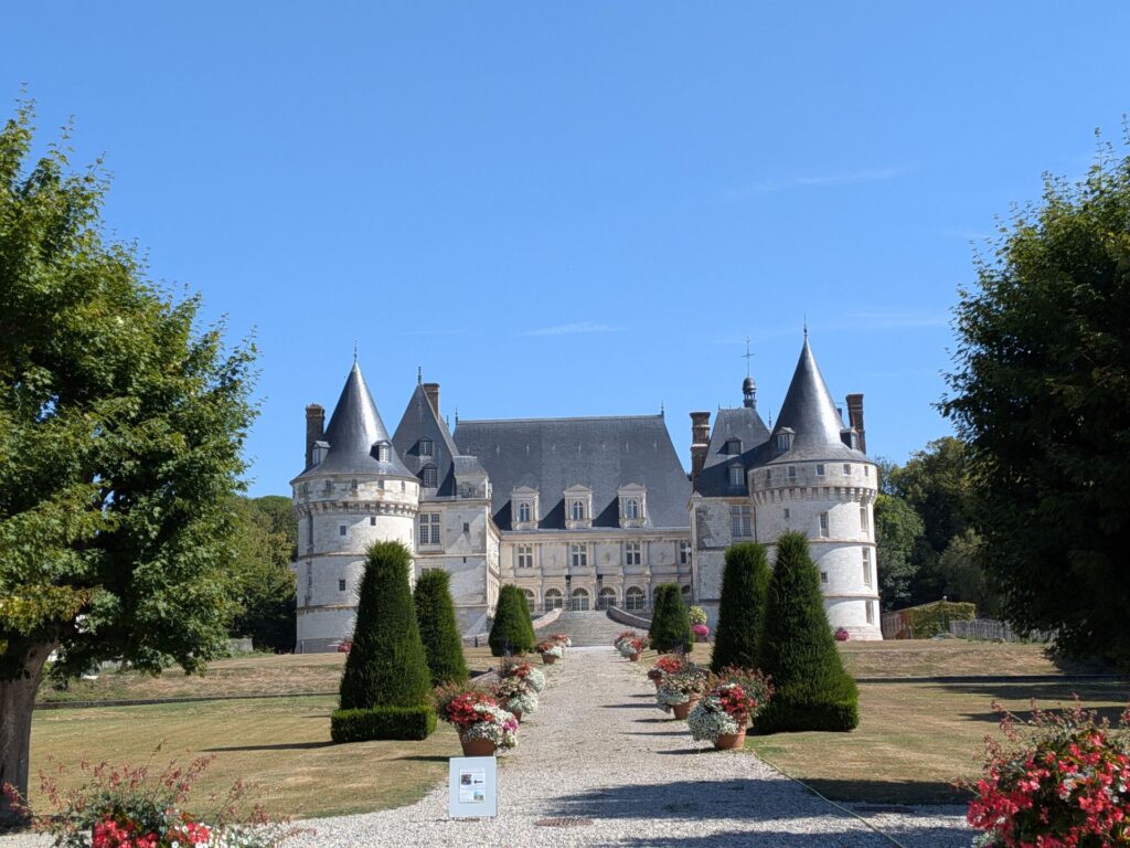 Un grand château blanc avec un toit en ardoises noires