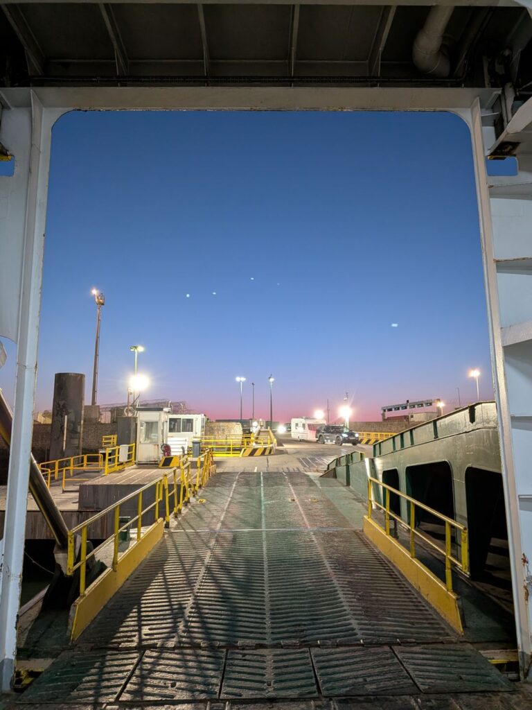 Vue de nuit depuis l'intérieur d'un ferry via la porte d'accès des voitures
