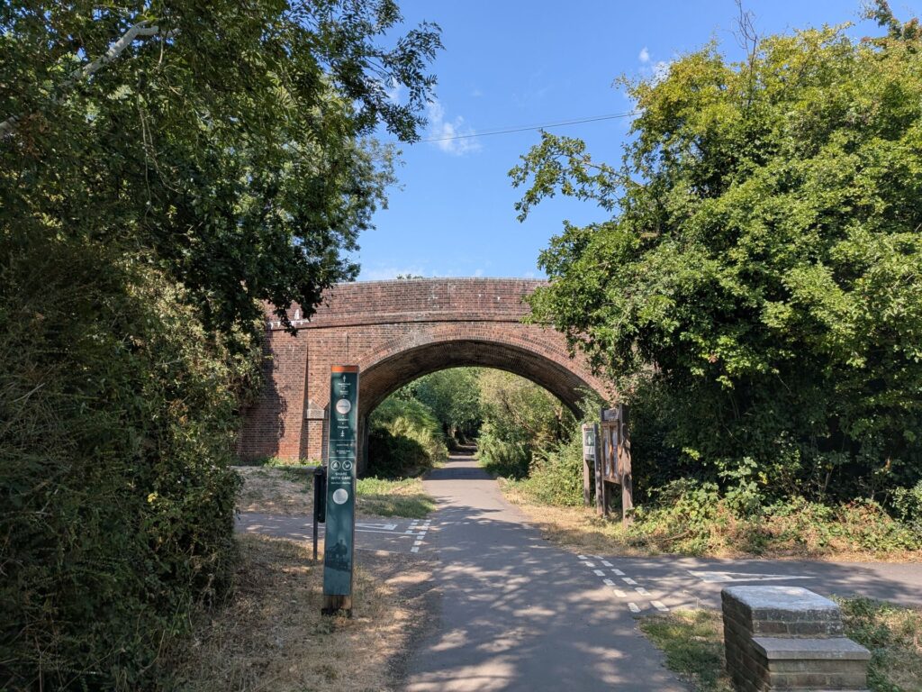 Un pont en brique passant au dessus d'une voie verte