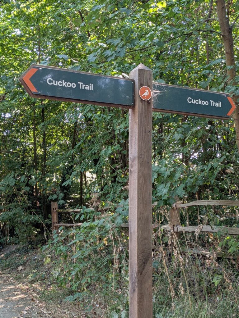 Un panneau de signalisation en bois composée de deux directions opposées indiquant "Cuckoo Trail" de chaque côté