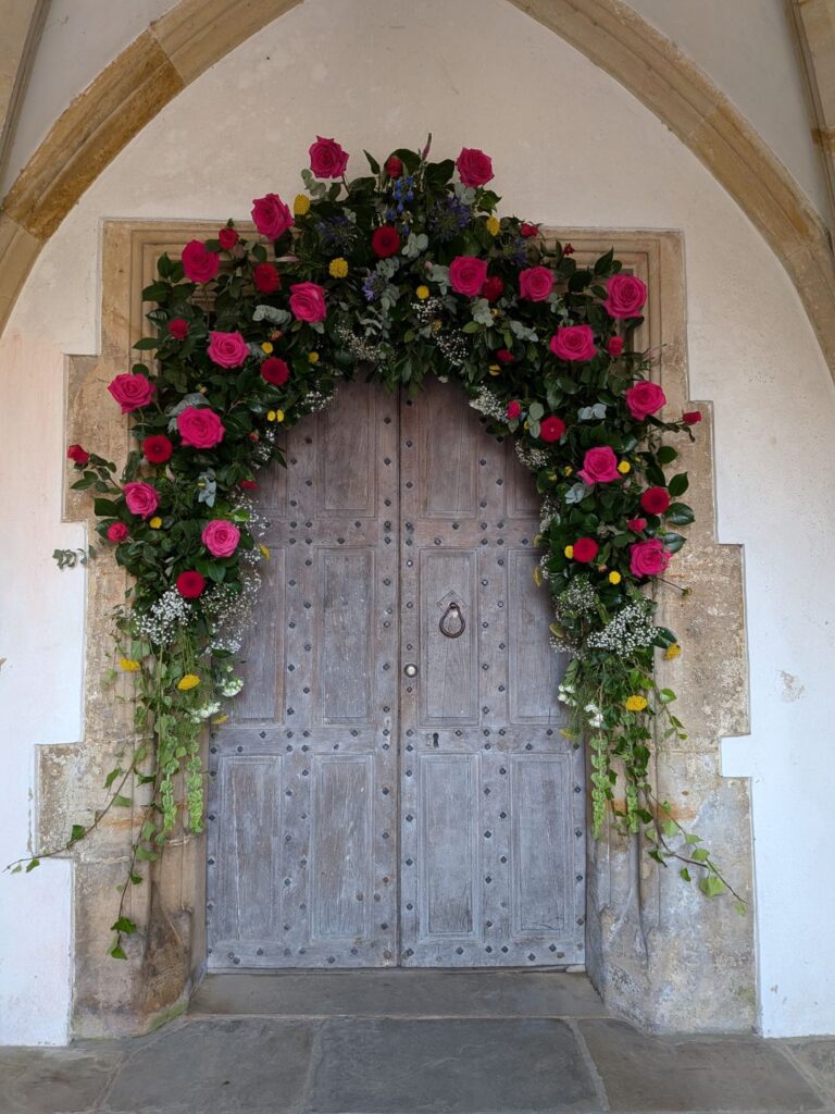 Porte d'entrée d'une église ornée sur toute l'arche de fleurs roses