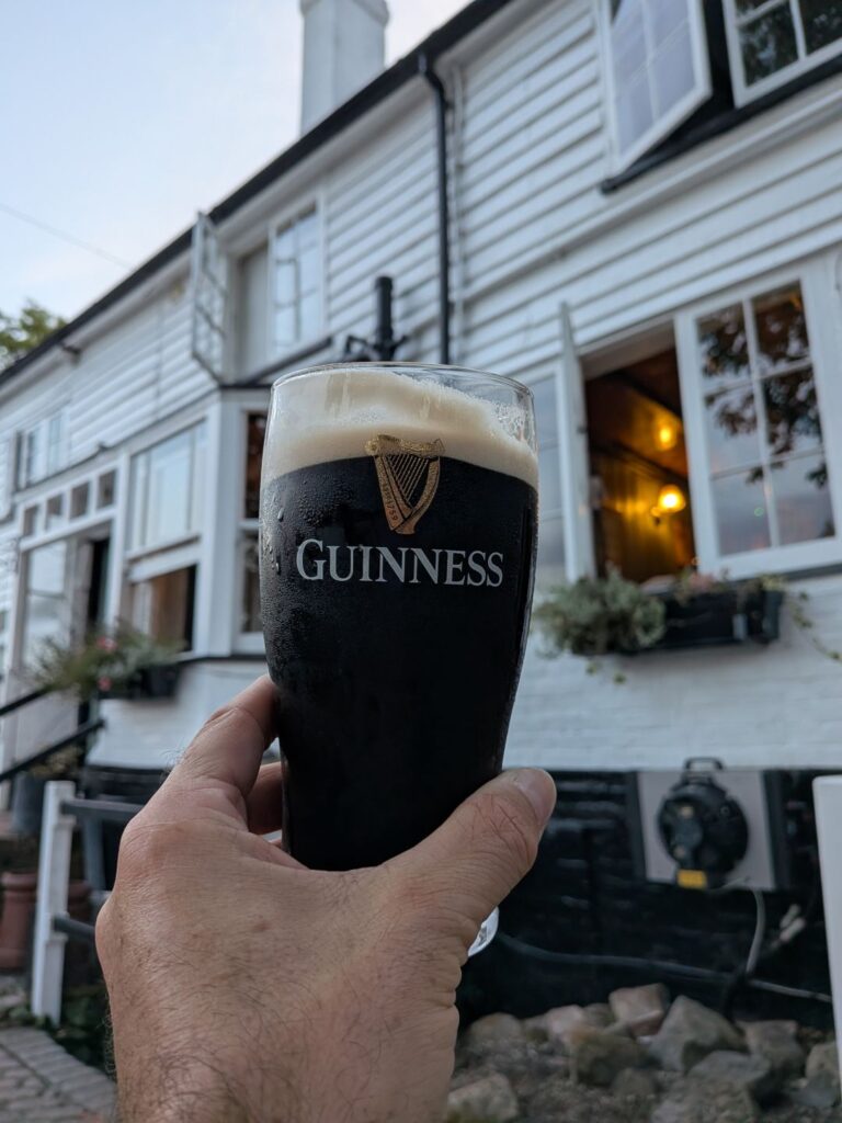 Une main qui tient une pinte de Guinness à l'extérieur d'un pub