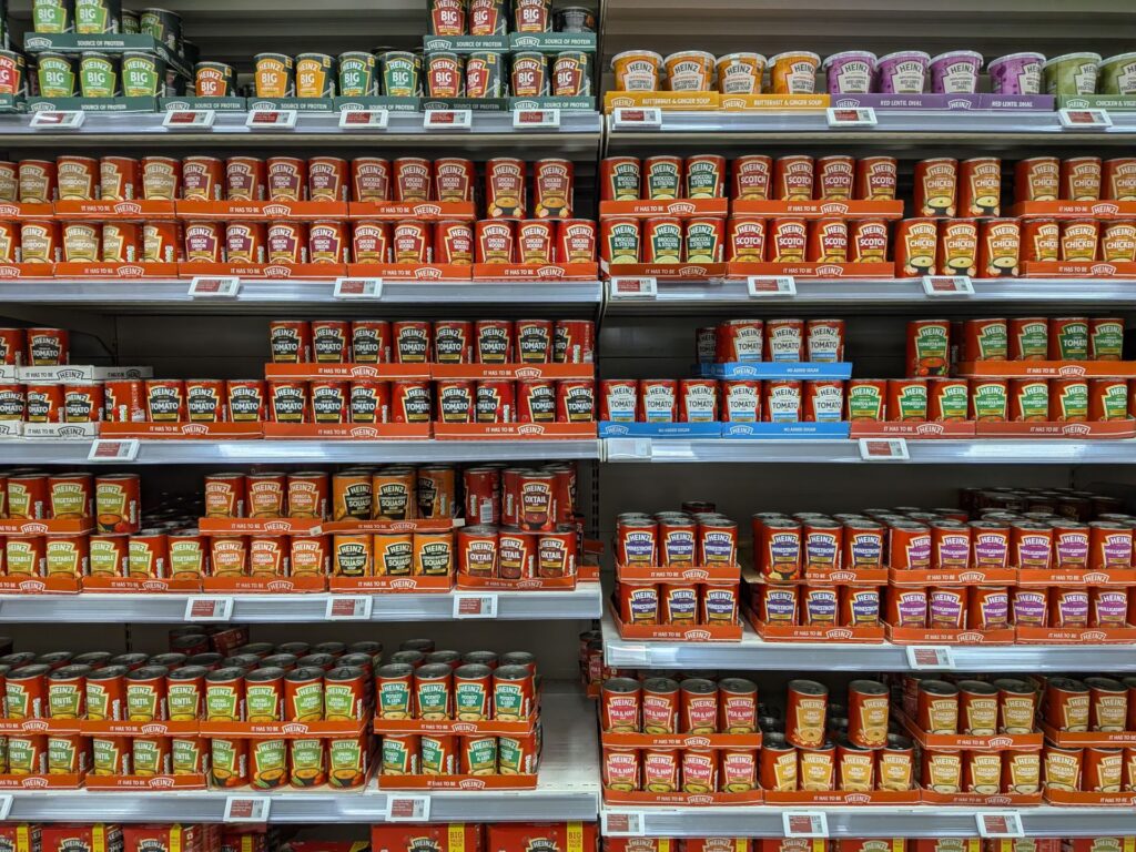 Plusieurs étagères dans un supermarché toutes occupées par de nombreuses variétés de sauces toutes de la marque Heinz
