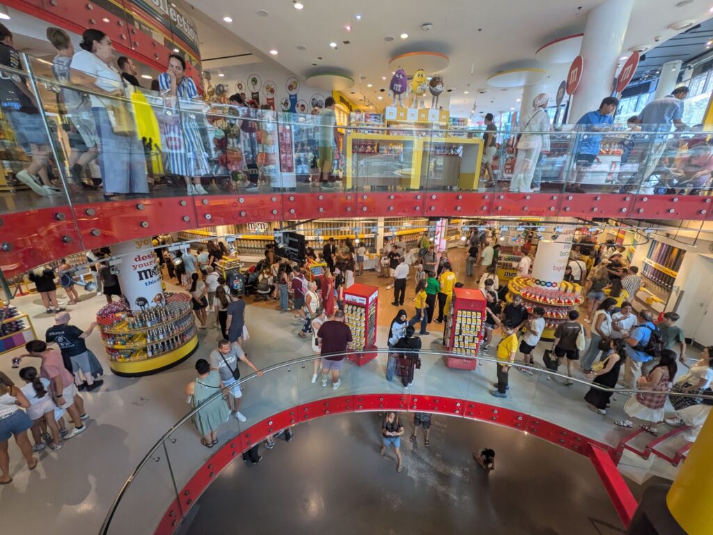 Vue panoramique de l'intérieur d'un magasin de M&Ms sur 3 étages. Beaucoup de couleurs et de stand de vente de bonbons