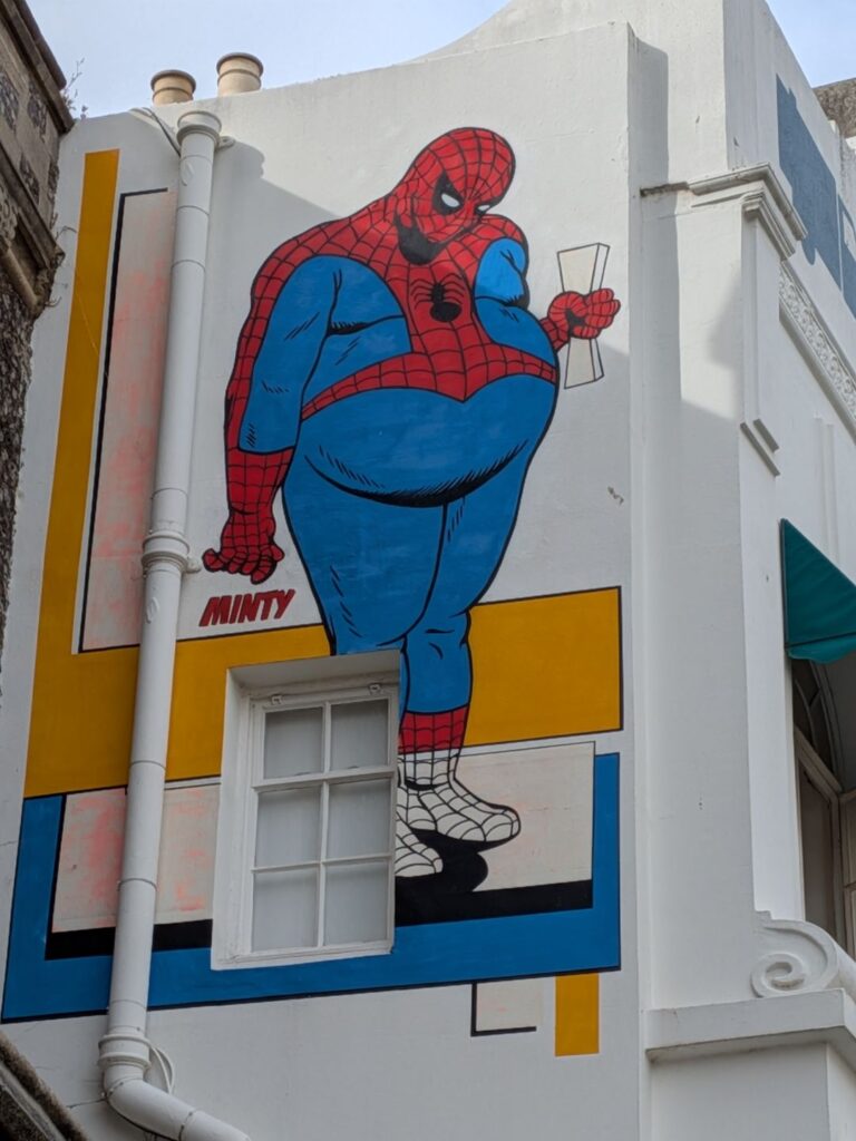 Graph sur un grand mur d'un Spiderman obèse qui se regarde le ventre