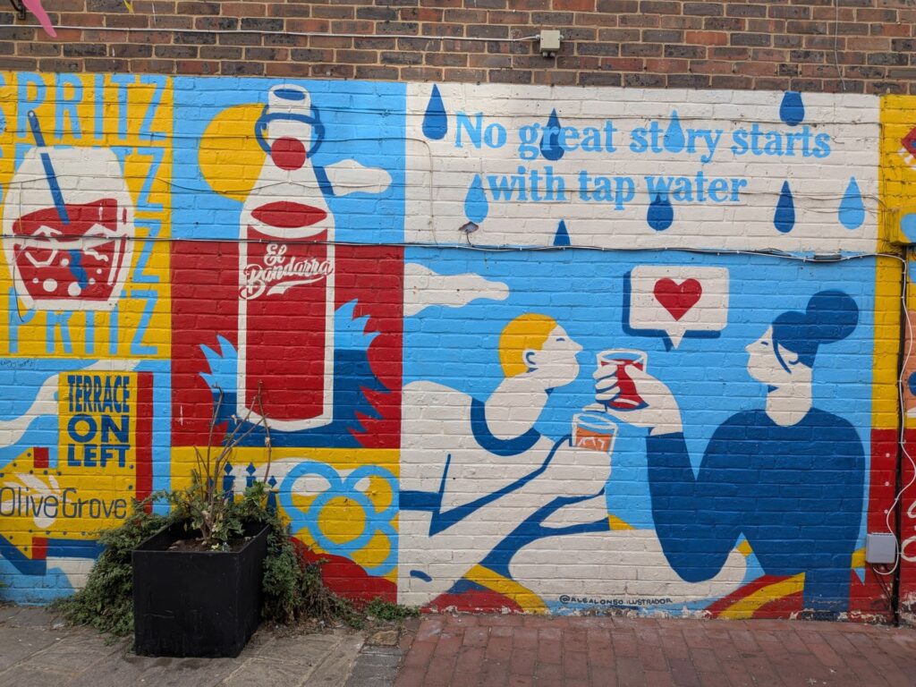 un graph aux couleurs vives (bleu/jaune/rouge/blanc), deux personnes trinquent avec un cœur en phylactère, texte "No great story starts with tap water"