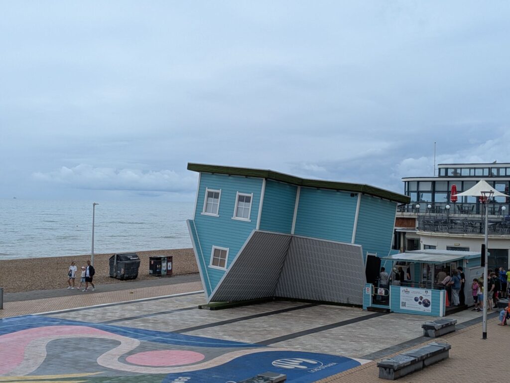 œuvre d'une maison bleue à taille réelle posée à l'envers sur le toit