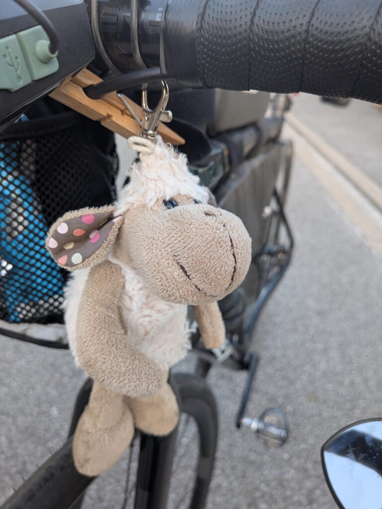 Petit mouton en peluche accroché à un vélo