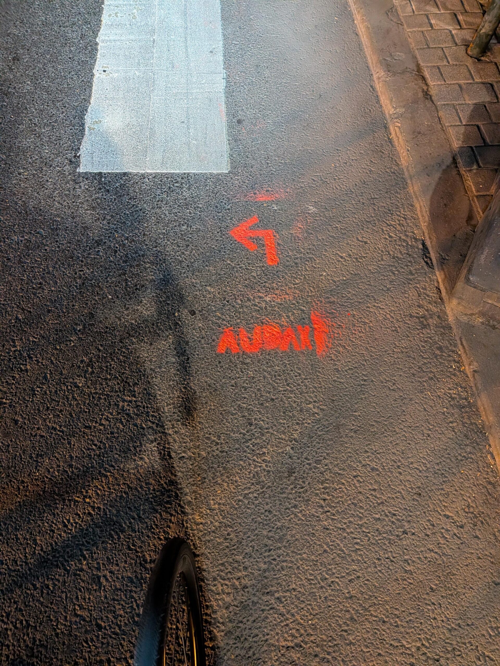 Au sol au pochoir en rouge une flèche vers la gauche et AUDAX