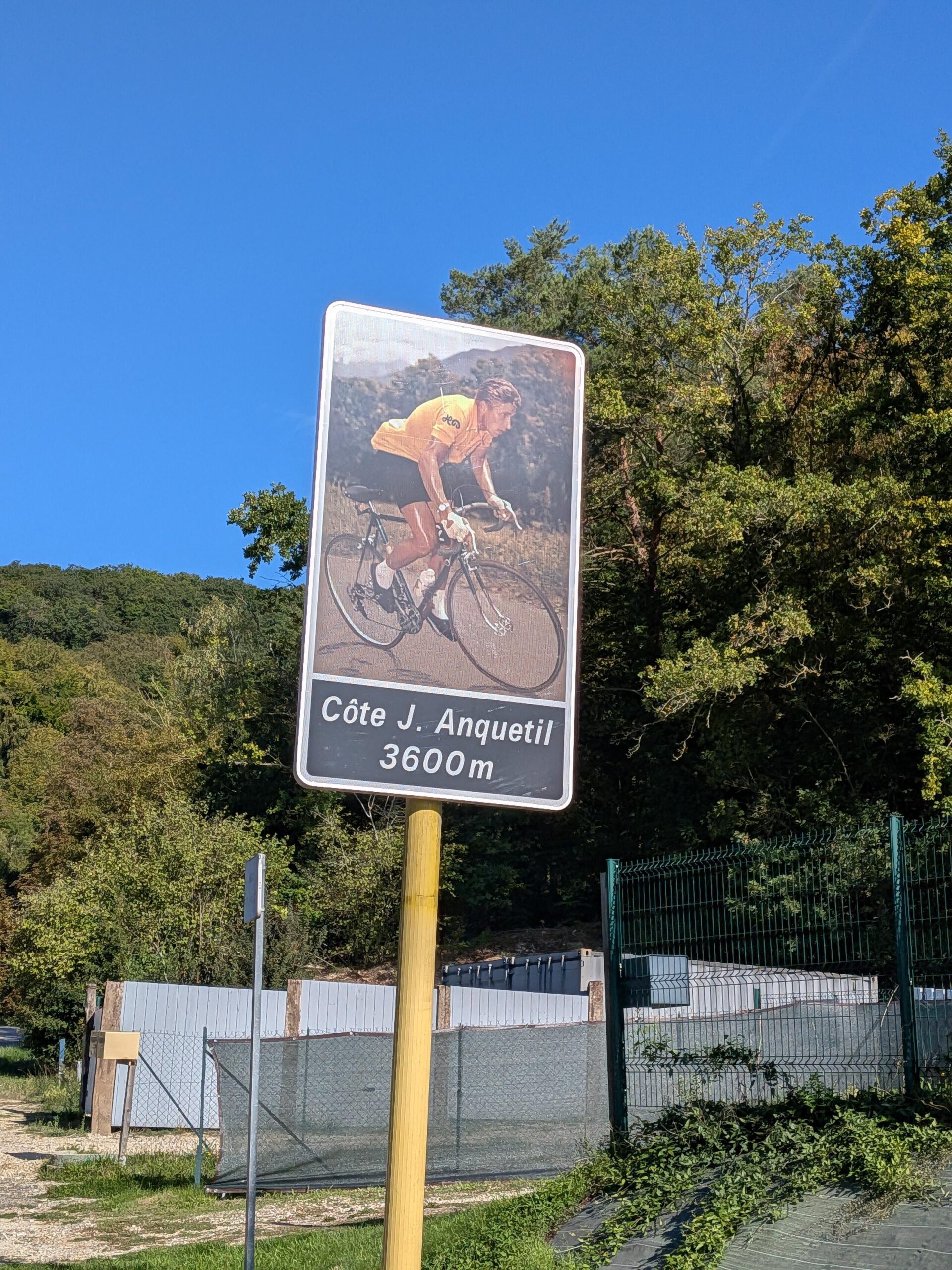 Panneau avec un cycliste en photo "Côte J. Anquetil 3600m"
