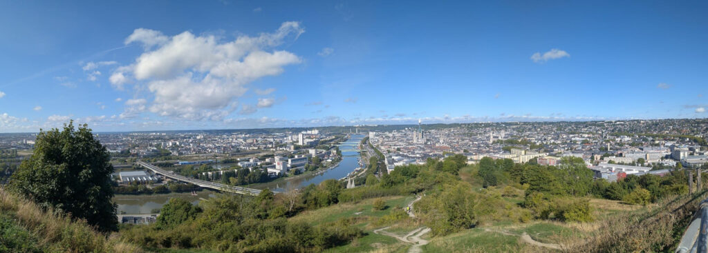 Vue panoramique d'une grande ville traversée par un fleuve (Rouen)